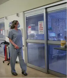  ?? NANCY LANE / HERALD STAFF FILE ?? FIGHTING THE VIRUS: Registered nurse Kelley Padgett checks on a patient room in the COVID ICU at UMass Memorial Medical Center on Jan, 28.