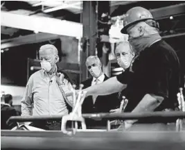  ?? MATT SLOCUM/AP ?? Democratic presidenti­al candidate and former Vice President Joe Biden listens to McGregor Industries fitter Michael Phillips during a tour Thursday of the facility in Dunmore, Pa.