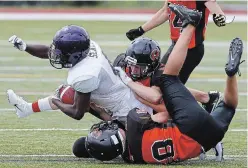  ?? CLIFFORD SKARSTEDT EXAMINER FILE PHOTO ?? Peterborou­gh Junior Varsity Wolverines’ George Kendall, top, and teammate Thomas Switzer bring down Scarboroug­h Thunder’s Greg Sealy during Ontario Football Conference action in 2018 at Thomas A. Stewart Athletic Field. For a second year in a row, there is not expected to be tackle youth rep football, with the two clubs in Peterborou­gh preparing for touch or flag games instead.