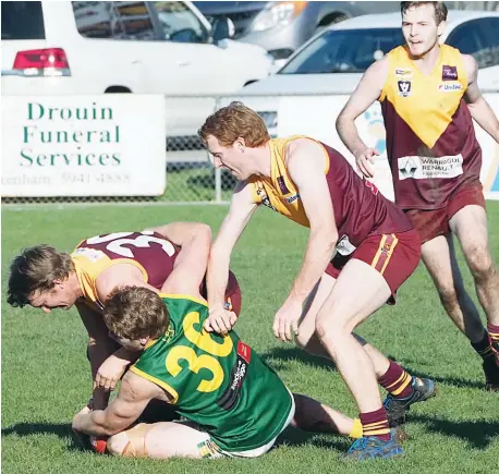  ??  ?? After an early barrage from Leongatha the Drouin defence settled and played a big part in getting the Hawks back into the game, on this occasion Leongatha’s Matt Borschman under plenty of pressure from backmen, from left, Wayne Morris, David Olsen and...