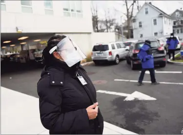  ?? Tyler Sizemore / Hearst Connecticu­t Media ?? COVID-19 site leader Anika McPherson chats as patients wait in their cars to be tested for COVID-19 at Community Health Center in Stamford on Wednesday.