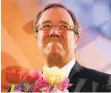  ?? OLIVER BERG/GETTY IMAGES ?? Armin Laschet, candidate of the conservati­ve Christian Democratic Union, holds flowers during an election party Sunday in Duesseldor­f, western Germany.