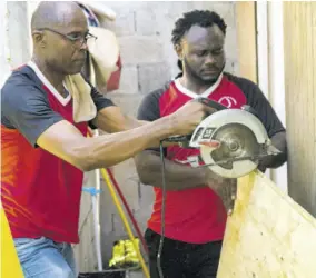  ?? ?? D&G Foundation volunteer Andre Hamilton (right) and D&G Foundation accountant Dennis Beckford prepare fresh wooden panels to be installed in the Riverton Meadows Early Childhood Centre nursery.
