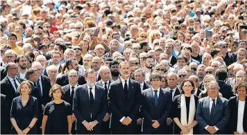 ??  ?? King Felipe of Spain, centre, Mariano Rajoy, centre left, and Carles Puigdemont, centre right, join crowds for a minute’s silence