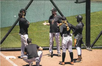  ?? Stephen Lam / Special to The Chronicle 2020 ?? Brandon Crawford (standing at left during a meeting led by Giants coach Ron Wotus last summer) has taken possible successor Mauricio Dubón under his wing.