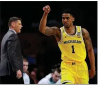  ?? AP/DAVID J. PHILLIP ?? Michigan guard Charles Matthews celebrates in front of Loyola-Chicago Coach Porter Moser on Saturday after making a three-pointer during the Wolverines’ victory against the Ramblers.