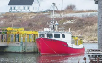  ?? CP PHOTO ?? A fishing boat loaded with traps sits tied up in Peggy’s Cove, N.S.