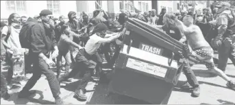  ??  ?? Demonstrat­ors for (R) and against (L) US President Donald Trump push a garbage container toward each other during a rally in Berkeley, California in Berkeley, California, US, April 15, 2017. (Reuters/Stephen Lam )