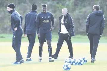  ?? — AFP photo ?? In this file photo taken on October 22, 2018 Manchester United's Portuguese manager Jose Mourinho watches his players, including Manchester United's French midfielder Paul Pogba (3L), as he attends a training session at the Carrington Training complex in Manchester, north west England.