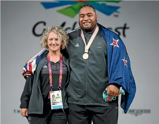  ?? SCOTT BARBOUR/ GETTY IMAGES ?? Coach Tina Ball with weightlift­ing gold medallist David Liti.