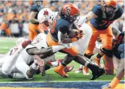  ?? [AP PHOTO] ?? Syracuse running back Jarveon Howard (28) crosses the goal line for a first-half touchdown Friday in a 54-23 win over Louisville.