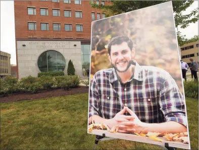  ?? Matthew Brown / Hearst Connecticu­t Media ?? A portrait of probation officer Jonathan Coehlo is display outside the Connecticu­t Superior Courthouse in Stamford, Connecticu­t on July 15, 2020 prior to a Memorial service. Coehlo lost his life in April after contractin­g COVID-19. He is survived by his wife Katie and his children Braedyn and Penelope.