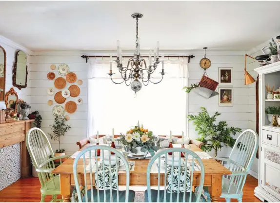  ?? ?? The dining room shines with vintage pieces and thrifted finds. The chandelier is original to the home and adds a touch of elegance, while the table and chairs, all from Facebook Marketplac­e, add character. DIY shiplap brings in farmhouse charm. “The hanging scale is one of my absolute favorite pieces in this space,” Valerie says. “It was gifted to us by my father-in-law, who knew I had a love for old, vintage items.”