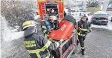  ??  ?? Feuerwehrl­eute machen das Zubehör für den Großlüfter einsatzber­eit.