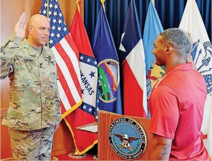  ?? [PHOTO BY MIREILLE MERILICE-ROBERTS, FOR THE OKLAHOMAN] ?? Maj. Gen. Michael Thompson, adjutant general for Oklahoma, at left, administer­s to Rodney Rideaux an Oath of Enlistment to the Oklahoma Army National Guard. The enlistment took place June 29 at the Oklahoma Military Entrance Processing Station in...