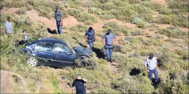  ?? Foto’s: Liezl van Niekerk ?? Nooddienst­e en polisie op die toneel waar die voertuig in die veld lê.