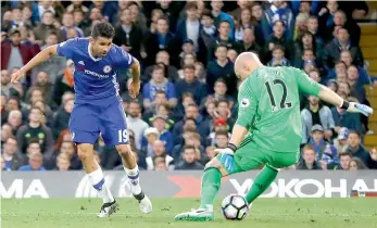  ?? — AP ?? Chelsea striker Diego Costa scores past Middlesbro­ugh goalkeeper Brad Guzan at Stamford Bridge in London on Monday. Chelsea won 3-0.