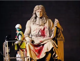  ??  ?? Un ouvrier de la Mairie de Paris nettoie la statue de Colbert, vandalisée par des activistes antiracist­es en juin 2020.