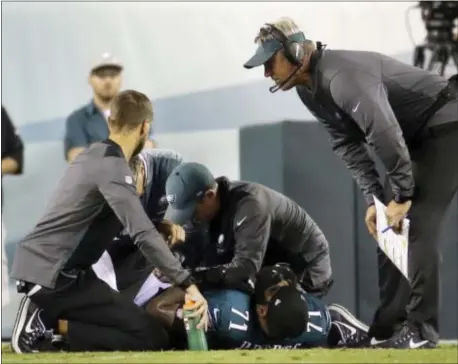  ?? MICHAEL PEREZ — THE ASSOCIATED PRESS ?? Eagles head coach Doug Pederson, right, joins trainers as they look at offensive tackle Jason Peters (71), injured during the second half of the Birds’ 34-24 win over the Washington Redskins Monday night at Lincoln Financial Field.