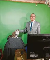  ?? Natalie Lyons / NYT ?? Jeff Lyons, a meteorolog­ist in Evansville, Ind., does a weather forecast with his cat, Betty, from his dining room. The cat was an immediate hit with viewers.