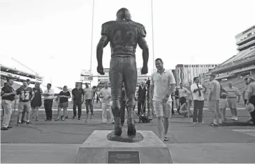  ?? DAVID KADLUBOWSK­I/AZCENTRAL SPOR ?? Zach Walz (right), who played alongside Pat Tillman examines the new statue during a unveiling ceremony at Sun Devil Stadium on Wednesday.