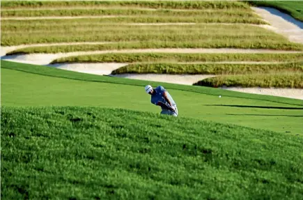  ?? GETTY IMAGES ?? Leader Dustin Johnson plays the third hole of the US Open, with Oakmont’s famed church-pew bunkers in the background.