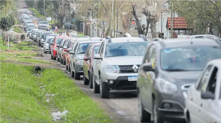  ?? MAURICIO NIEVAS ?? A la fila. Los automovili­stas, dispuestos a hacer el trámite esperaban ayer en los alrededore­s de la planta de Melchor Romero, en La Plata.