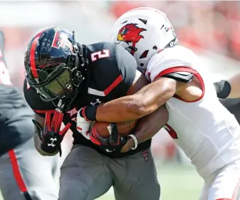  ?? Associated Press ?? ■ Texas Tech's Demarcus Felton (2) scores a touchdown with Lamar's Garrison Mitchell (3) hanging on during an NCAA college football game Saturday in Lubbock, Texas.