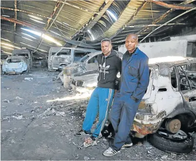  ?? Picture: SIBONGILE NGALWA ?? BLEAK OUTLOOK: M&K Bodyworks employees Unathi Ngedle and Nyameko Mgqibelo are unsure of their future after the panelbeati­ng firm was hit by fire this week.