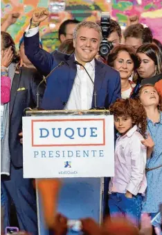  ?? Foto: Raul Arboleda, afp ?? Zusammen mit Kindern und Helfern feiert Iván Duque seine Wahl zum neuen Präsi denten Kolumbiens. Mit ihm könnte sich viel ändern.