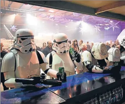  ?? OLI SCARFF / AFP ?? Seguidores de Star Wars disfrazado­s de tropas de asalto, el viernes, en una convención en Manchester
