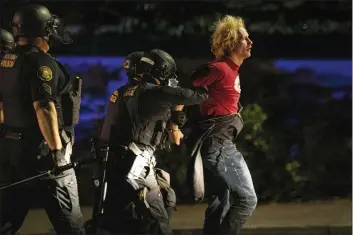  ?? IL — PAULA BRONSTEIN ?? In this Aug. 302020file photo police make arrests on the scene of protests at a Portland police precinct on in Portland, Ore.