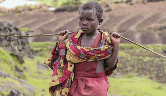  ??  ?? TOP: A girl from the Gahinga Batwa Village in one of the community’s farming fields.