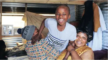  ?? Picture: HENK KRUGER ?? ELATION: Ona Dubula’s motherPhum­eza Dubula and grandmothe­r Nombulelo play with him in a relative’s home in Imizamo Yethu. Ona is back from Groote Schuur Hospital after undergoing surgery to remove a rubber bullet from under his tongue.