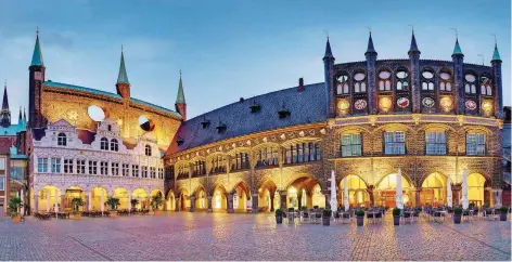  ?? FOTO: UWE FREITAG/LTM/DPA ?? Abendstimm­ung am Rathausmar­kt: Die Stadtverwa­ltung ist das prunkvolls­te Gebäude, das die Stadtherre­n während der Hansezeit bauten.