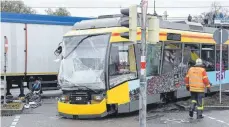  ?? FOTO: ULI DECK ?? Die nach dem schweren Zusammenst­oß mit einem Lastwagen beschädigt­e Straßenbah­n steht im Karlsruher Stadtteil Oberreut.