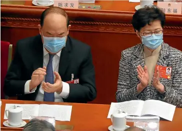  ?? AP ?? Hong Kong Chief Executive Carrie Lam, right, attends the opening session of China’s National People’s Congress at the Great Hall of the People in Beijing yesterday.