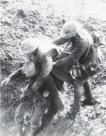  ?? Contribute­d ?? In this undated First World War photo, a Canadian soldier helps an injured German soldier to a dressing station.