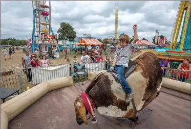  ?? NWA Democrat-Gazette/J.T. WAMPLER ?? Levi Goodman, 6, rides a mechanical bull Saturday at the 119th Tontitown Grape Festival. The festival began in 1898 when at least 40 Italian immigrant families celebrated a harvest in their newfound home.