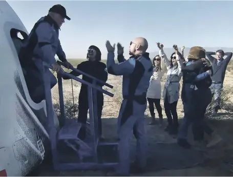  ?? EPA ?? William Shatner is applauded by Blue Origin founder Jeff Bezos, centre, as the 90-year-old ‘Star Trek’ actor climbs out of the capsule on his return to Earth after a brief journey into space aboard the New Shepard rocket yesterday