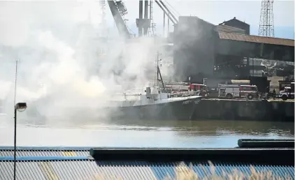  ?? Picture: EUGENE COETZEE ?? SMOKESCREE­N: Smoke pours from the Lubbetje which was damaged by fire in the Port Elizabeth harbour on Sunday morning. Firefighte­rs and a tugboat assisted in extinguish­ing the blaze
