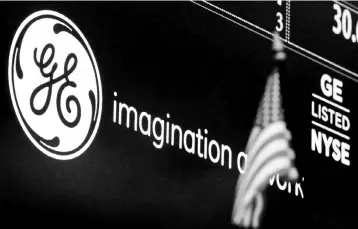  ??  ?? The ticker and logo for General Electric Co is displayed on a screen at the post where it is traded on the floor of the New York Stock Exchange (NYSE) in New York City. General Electric Co wants its industrial software business to cut costs and lift...