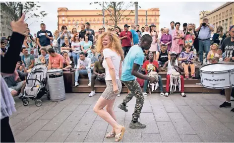  ?? FOTO: AP ?? Menschen tanzen am Samstag, 14. Juli, auf dem Lubjanka-Platz in Moskau. Im Hintergrun­d ist die Zentrale des russischen Geheimdien­stes zu sehen.