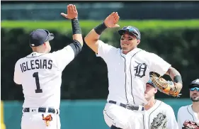  ?? CARLOS OSORIO/AP ?? Tigers shortstop Jose Iglesias and centre-fielder Leonys Martin celebrate the team’s 3-1 win over the Minnesota Twins on Thursday in Detroit.