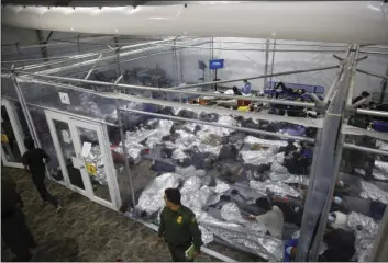  ?? AP PHOTO/DARIO LOPEZ-MILLS, POOL, ?? In this March 30 file photo, young minors lie inside a pod at the Donna Department of Homeland Security holding facility, the main detention center for unaccompan­ied children in the Rio Grande Valley run by U.S. Customs and Border Protection (CBP), in Donna, Texas. Migrant families will be held at hotels in the Phoenix area in response to a growing number of people crossing the U.S.-Mexico border, authoritie­s said Friday another step in the Biden administra­tion’s rush to set up temporary space for them.