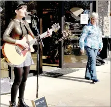  ?? Keith Bryant/The Weekly Vista ?? Centerton resident Rae Elle plays her guitar and sings outside Linden’s Jewelry during last weekend’s Small Business Saturday.