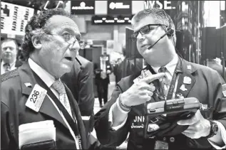  ??  ?? Traders Steven Kaplan, left, and John Panin converse Friday on the floor of the New York Stock Exchange.