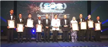  ??  ?? Senior officers who received the ‘Pegawai Contoh Perkhidmat­an Negeri’ award in a photo call with Abang Johari (centre), who is flanked by Mohamad Morshidi (fifth right) and Mansor.