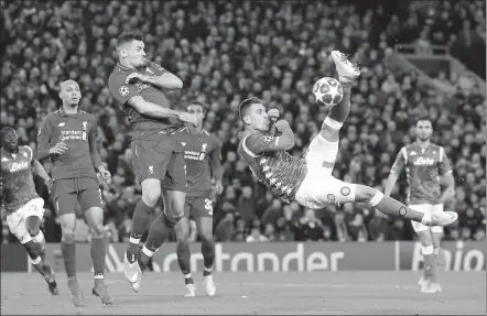  ?? JON SUPER / ACTION IMAGES VIA REUTERS ?? Napoli’s Arkadiusz Milik attempts an acrobatic volley as Liverpool’s Dejan Lovren defends during Tuesday’s Champions League Group C match at Anfield. The Reds won 1-0 to qualify for the last 16.