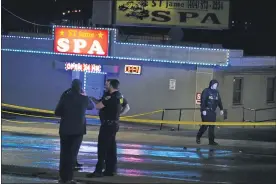  ?? BRYNN ANDERSON — THE ASSOCIATED PRESS ?? Law enforcemen­t officials confer outside a massage parlor following a shooting on Tuesday, in Atlanta. Shootings at two massage parlors in Atlanta and one in the suburbs have left multiple people dead, many of them women of Asian descent, authoritie­s said Tuesday.